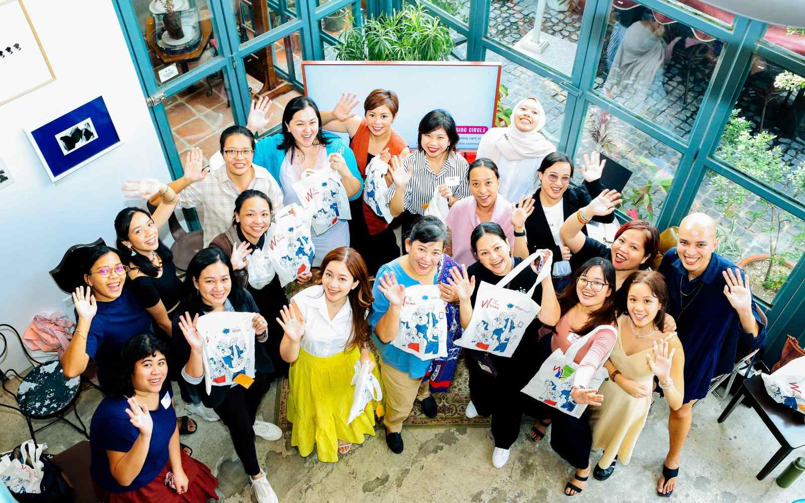 A group of Filipina women waving at the camera