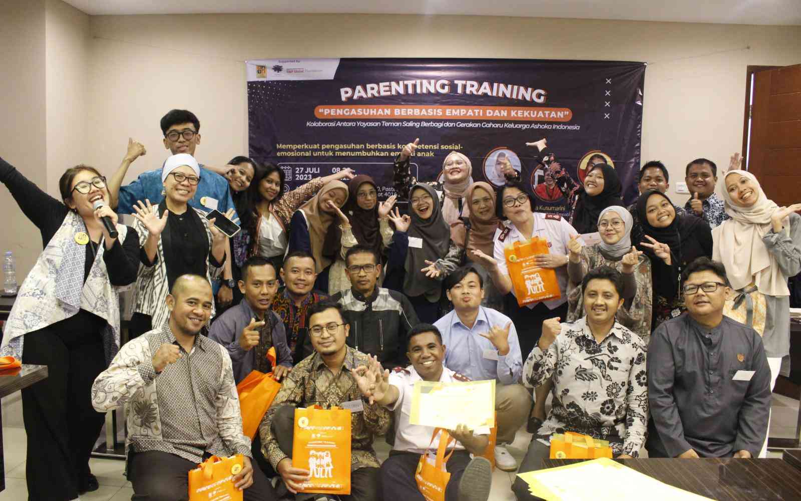 A group of people pose in front of a sign that says "Parenting Training"