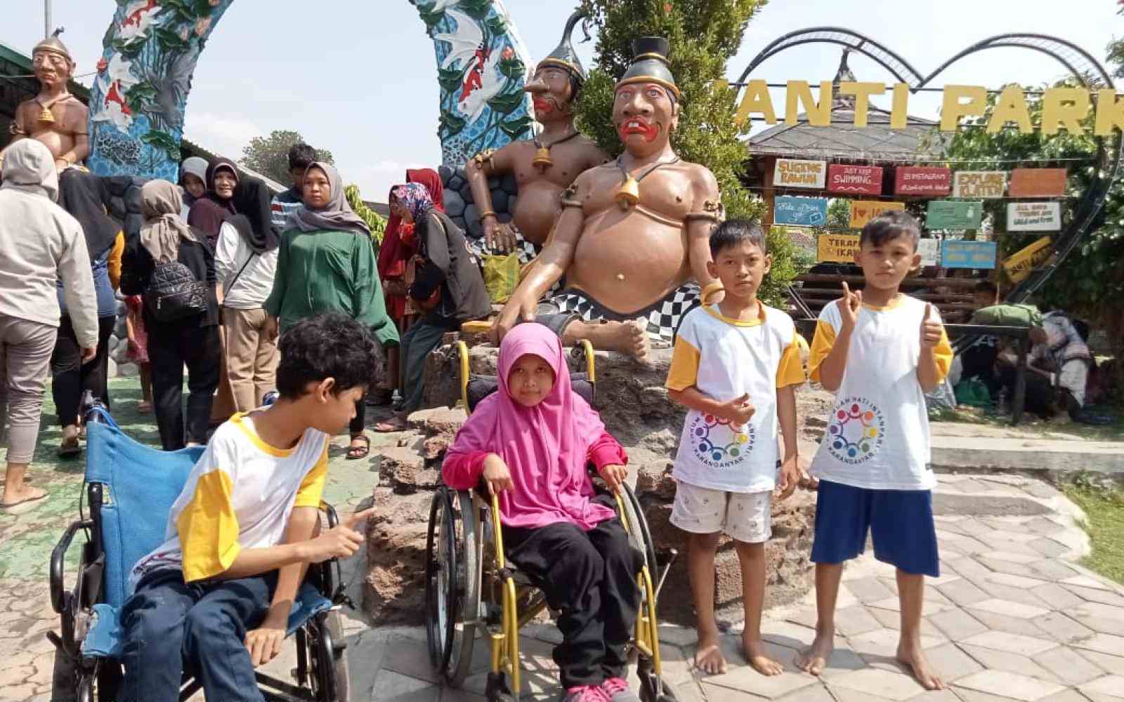Indonesian children posing in a cultural park, some are in wheelchairs