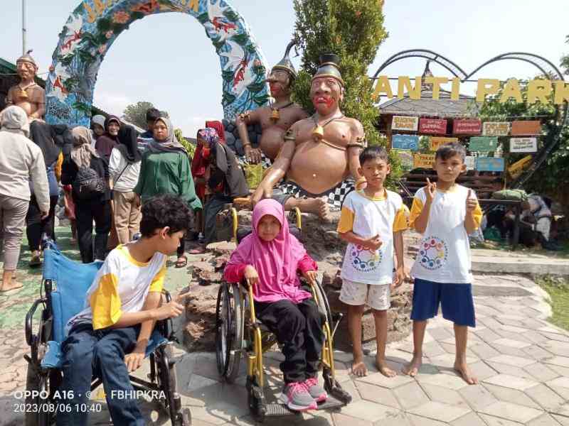 Indonesian children posing in a cultural park, some are in wheelchairs