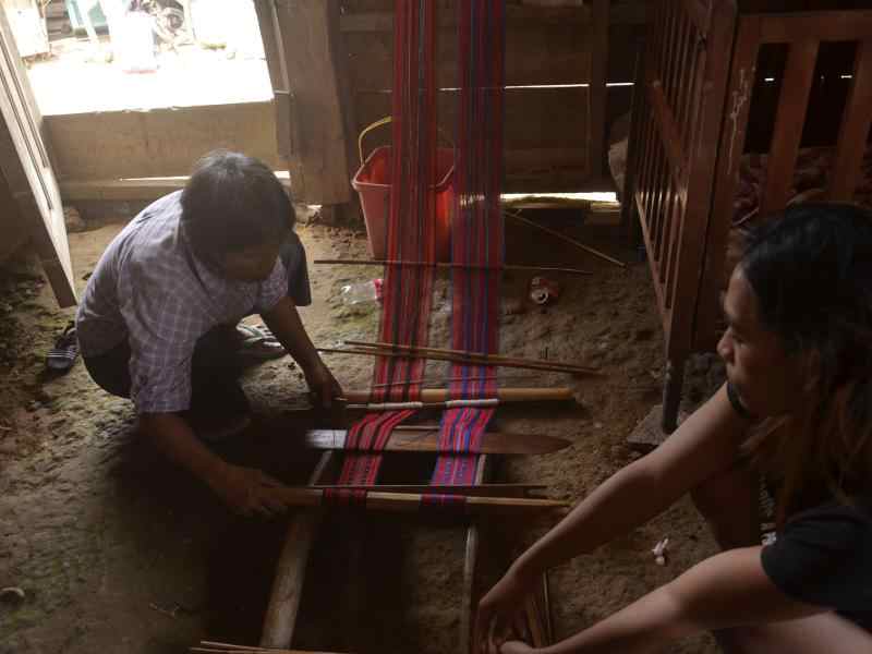 Two Filipinas using a loom